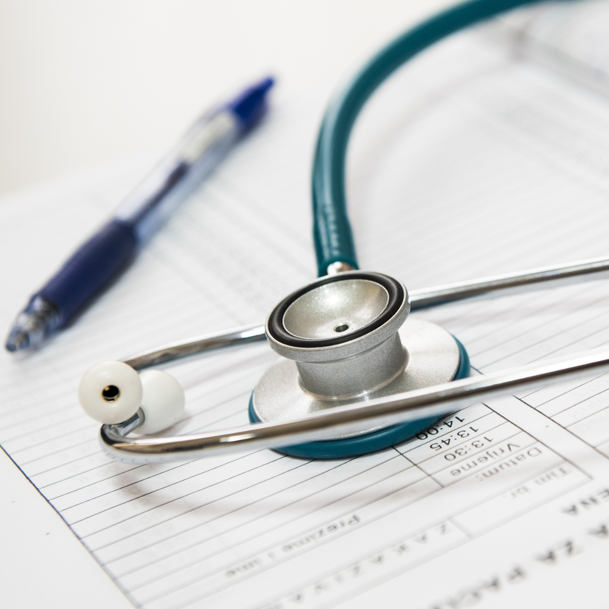 stethoscope with pen and paperwork in background_cropped