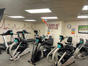 A cardiac rehab exercise area with recumbent bikes and treadmills