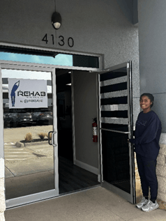 A woman propts the door to the Rescue MD Intensive Cardiac Rehab facility open. 