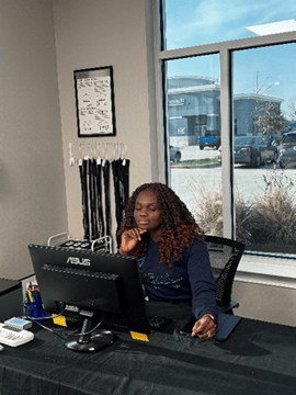 Dr. Okoro sits at a desk looking at her computer.