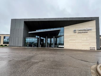 CentraCare Long Prarie's Cardiac Rehab building. The building is a grey rectangle with interestingly geometric components, including large windows, contrasting colors and a covered entrance. 